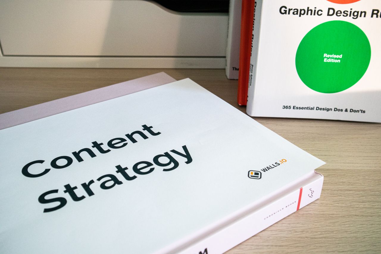 services-03 Books on content strategy and graphic design essentials resting on a wooden desk.